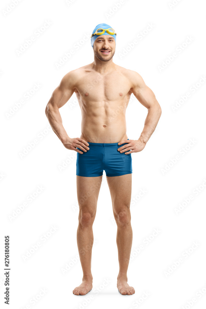 Man in swimming shorts, googles and a cap posing