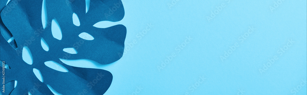 top view of blue exotic paper cut palm leaves on blue background with copy space, panoramic shot top view of blue exotic paper cut palm leaves on blue background with copy space, panoramic shot
