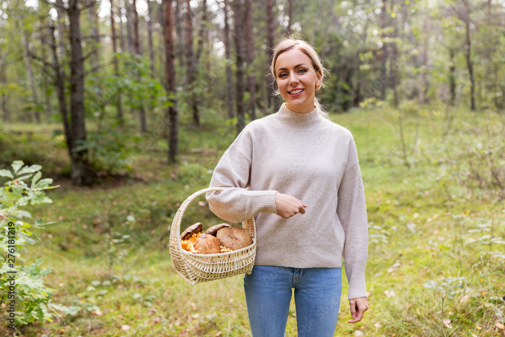 season and leisure people concept - young woman with mushrooms in wicker basket in forest season and leisure people concept - young woman with mushrooms in wicker basket in forest