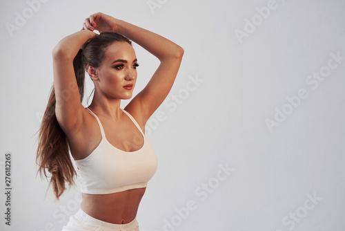 Keeping hair in shape. Portrait of seductive brunette in the studio with white background