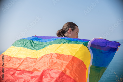 Young girl from behind  holding a banner looking at the sea