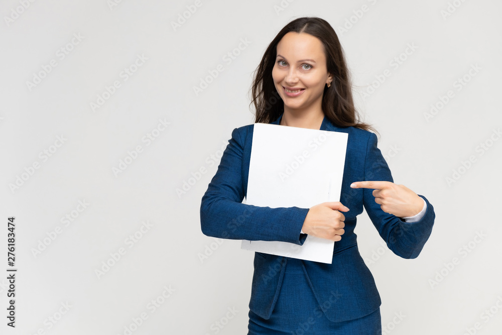 Portrait of a young pretty brunette manager woman of 30 years in a business blue suit with beautiful dark hair. Standing with a folder on a white background, talking, showing hands, with emotions Portrait of a young pretty brunette manager woman of 30 years in a business blue suit with beautiful dark hair. Standing with a folder on a white background, talking, showing hands, with emotions