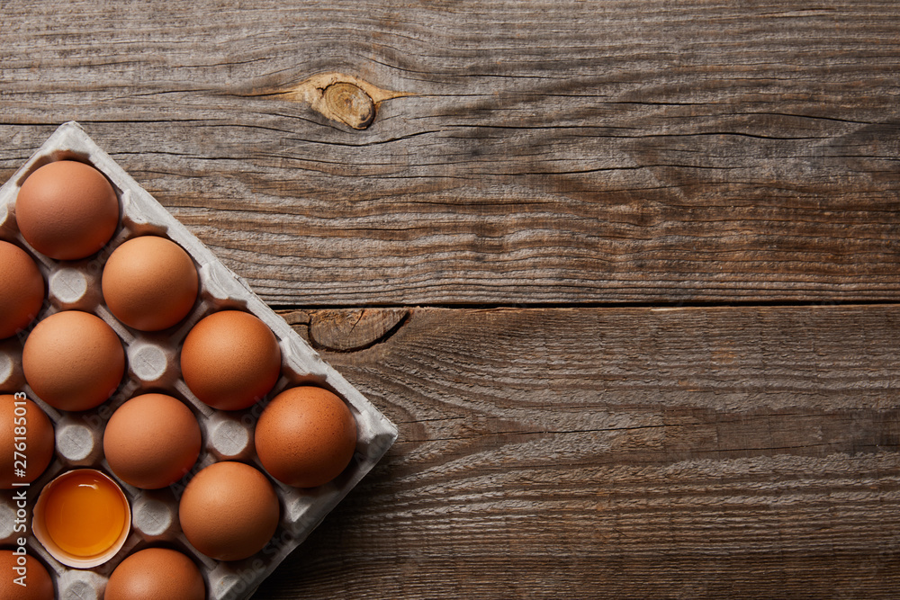 top view of chicken eggs in carton box on wooden table top view of chicken eggs in carton box on wooden table