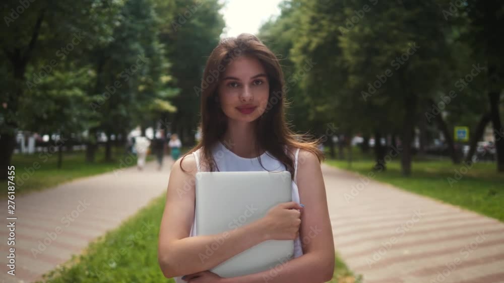 Portrait of beautiful brunette student woman outdoor in the summer, looking and smiling close-up. Portrait of young girl outdoor in park Portrait of beautiful brunette student woman outdoor in the summer, looking and smiling close-up. Portrait of young girl outdoor in park