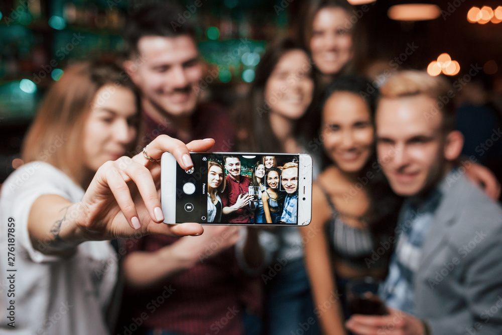 Picture of girl taking photo of herself and her friends at the party Picture of girl taking photo of herself and her friends at the party
