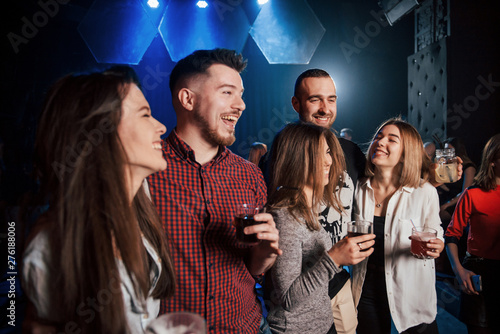 Making a jokes. Beautiful youth have party together with alcohol in the nightclub