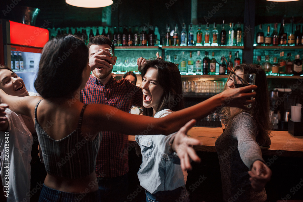 Wide hugs. Beautiful youth have party together with alcohol in the nightclub
