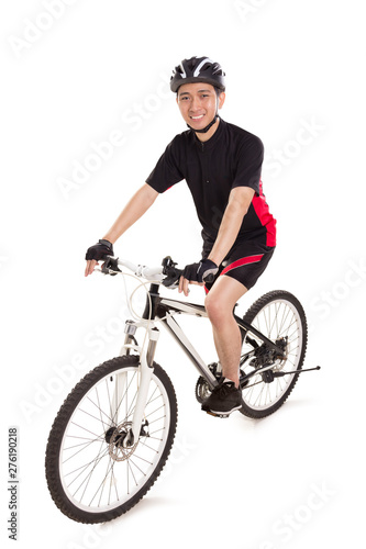 Full length portrait of an Asian man rides a bicycle and smiles at camera, isolated over white background