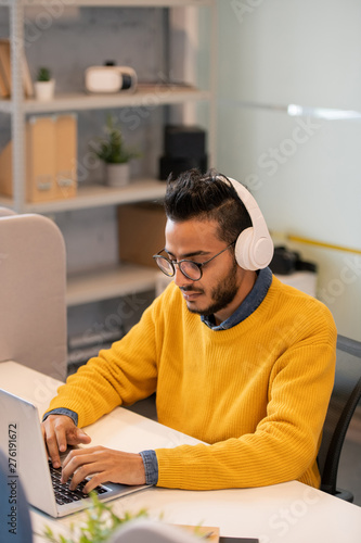 Young business intern using laptop photo