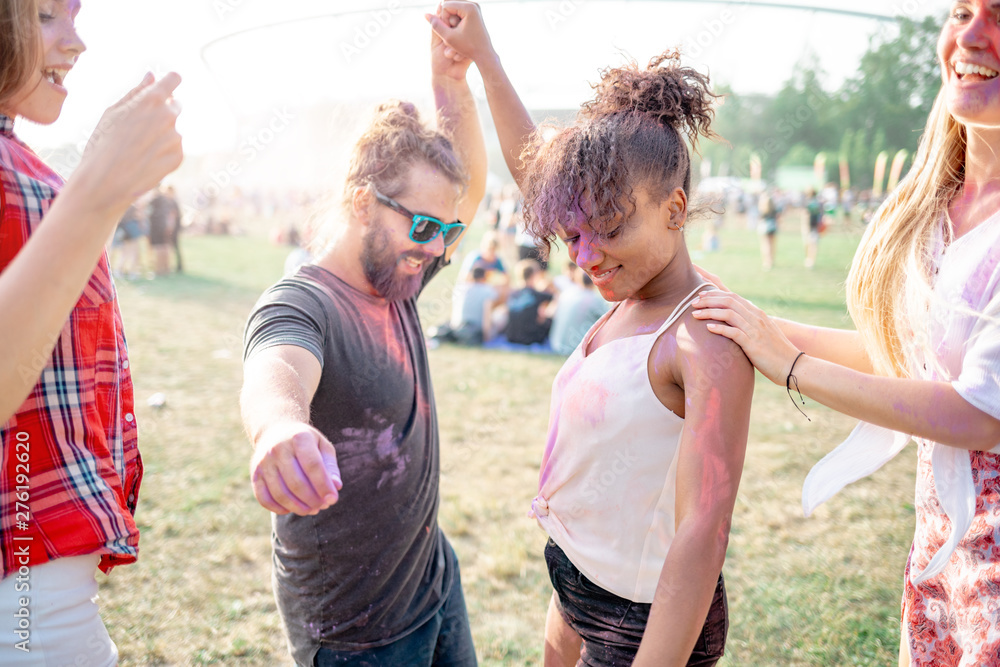 Obraz premium Multiethnic group of friends dancing at holi festival
