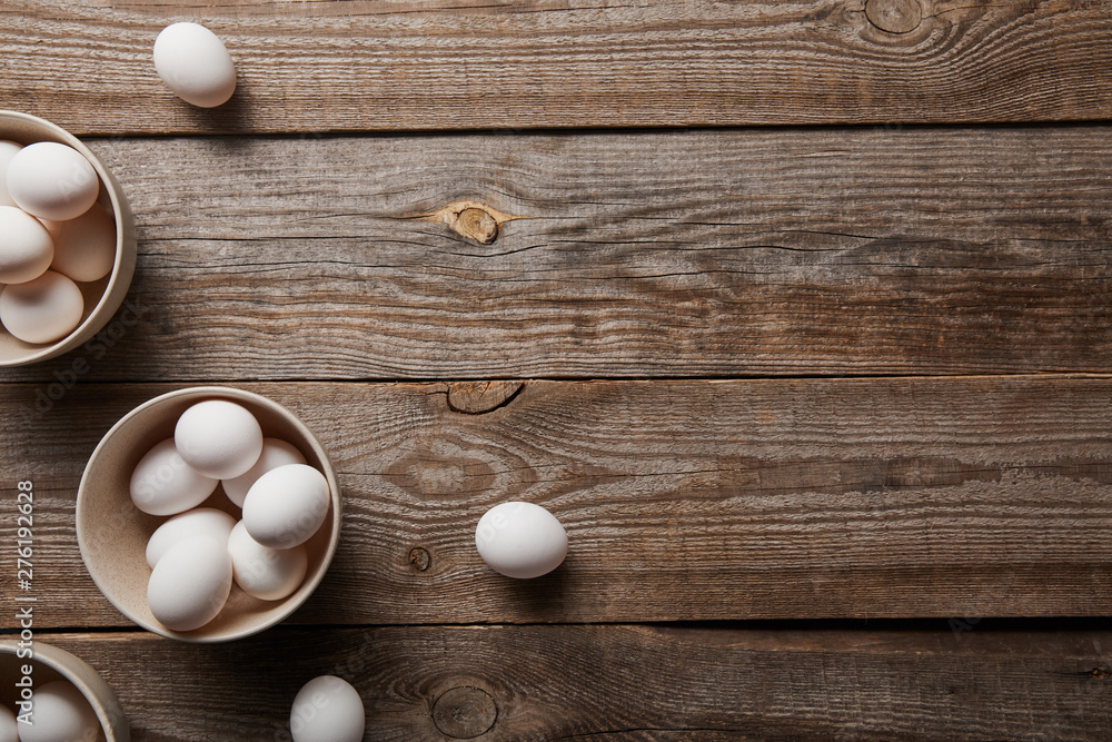 top view of chicken eggs in bowls on wooden table top view of chicken eggs in bowls on wooden table