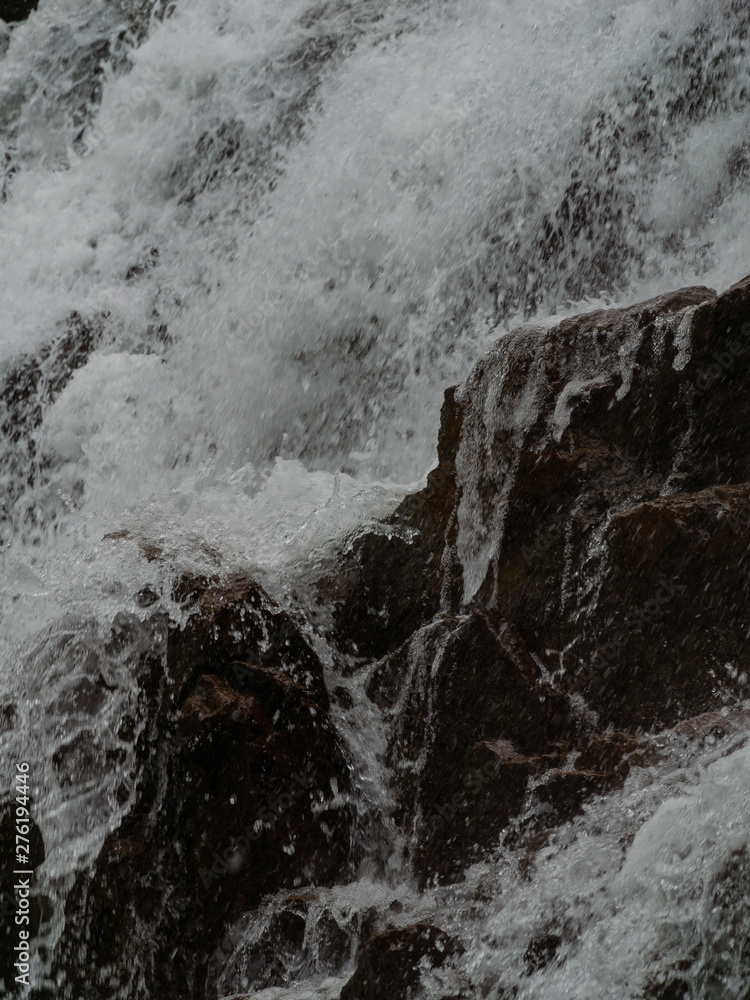 Stormy waters of the northern waterfall in a rocky gorge on the shores of the cold sea Stormy waters of the northern waterfall in a rocky gorge on the shores of the cold sea