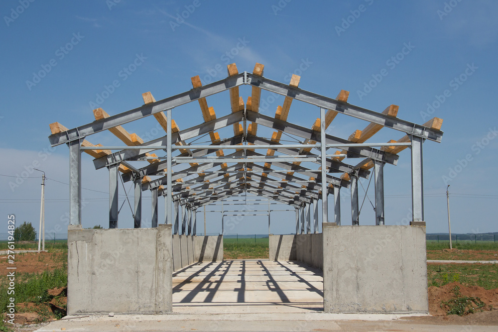 Background from the village hangar on construction site. Reinforced concrete base and metal frame of the building. Background from the village hangar on construction site. Reinforced concrete base and metal frame of the building.