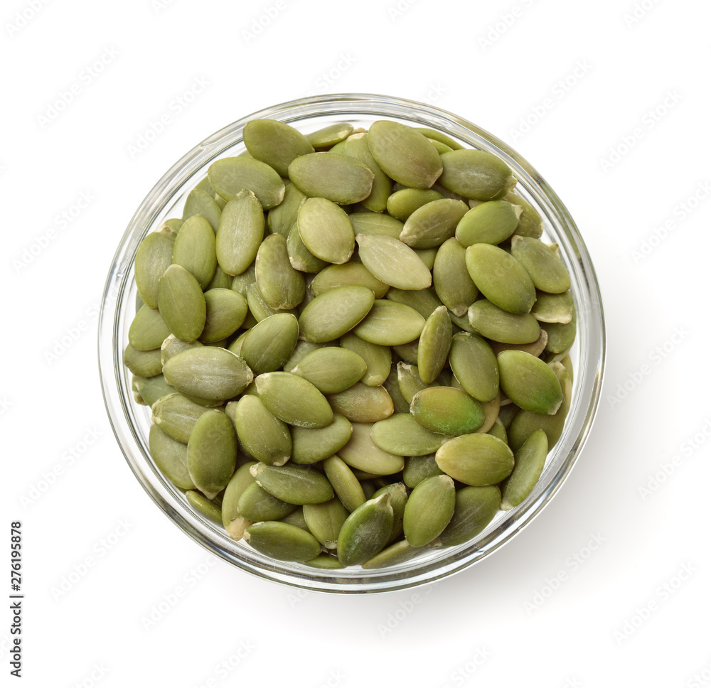 Top view of pumpkin seeds in glass bowl - obrazy, fototapety, plakaty 