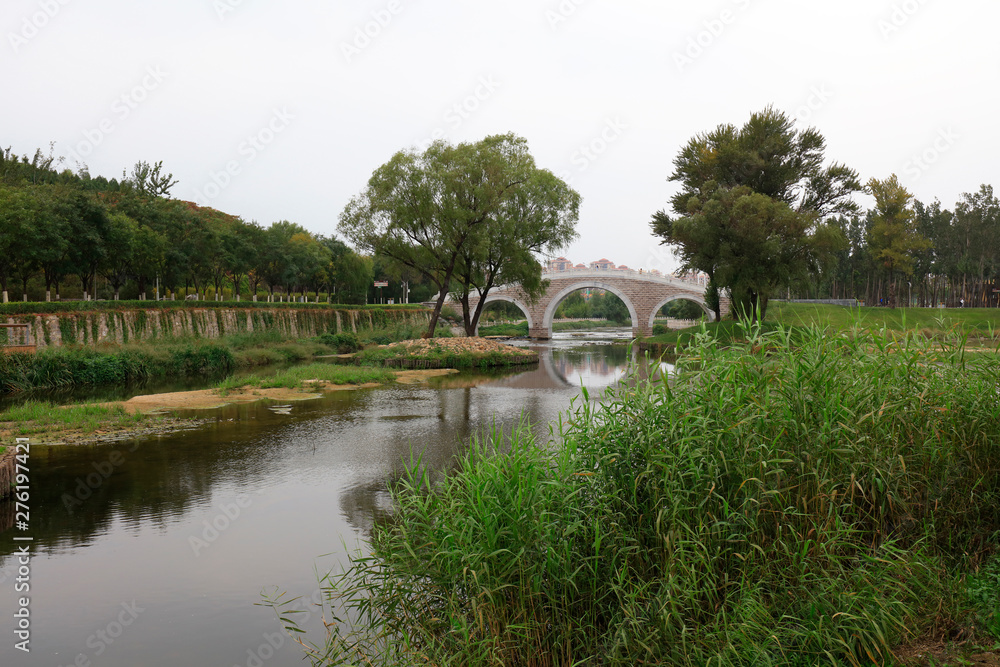 Fototapeta premium stone arch bridge built in a park