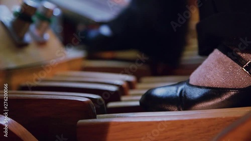Slow motion close up view of female feets pushing the pipe organ pedals, playing the organ. Musician, profession concept. Concert hall or church interior.