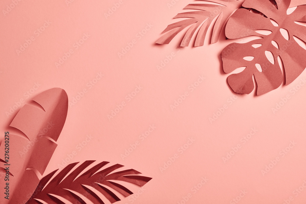 Fototapeta premium widok z góry na egzotyczne liście cięcia papieru na różowym tle z miejsca na kopię