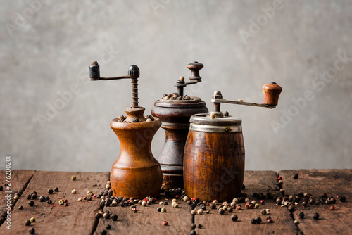 Vintage wooden pepper mills with peppercorns