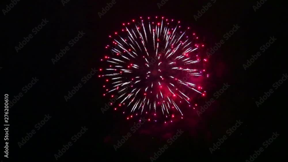 Bright balloons of festive fireworks in the night sky over the river. Time laps Bright balloons of festive fireworks in the night sky over the river. Time laps