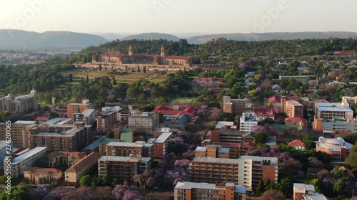 Aerial view of The Union Buildings, government offices in Pretoria, South Africa and the surrounding traffic and cityscape buildings in the capital city with blooming Jacaranda trees.