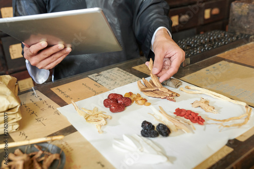Φωτογραφία Hands of practitioner putting traditional treatment ingredients on white sheet i