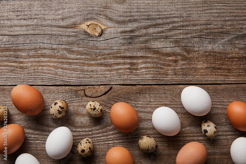 top view of quail and chicken eggs on wooden table