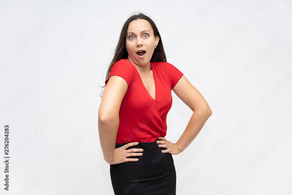 Portrait to the waist of a young pretty brunette woman of 30 years old in a bright red sweater with beautiful dark hair. Standing on a white background, talking, showing hands, with emotions Portrait to the waist of a young pretty brunette woman of 30 years old in a bright red sweater with beautiful dark hair. Standing on a white background, talking, showing hands, with emotions