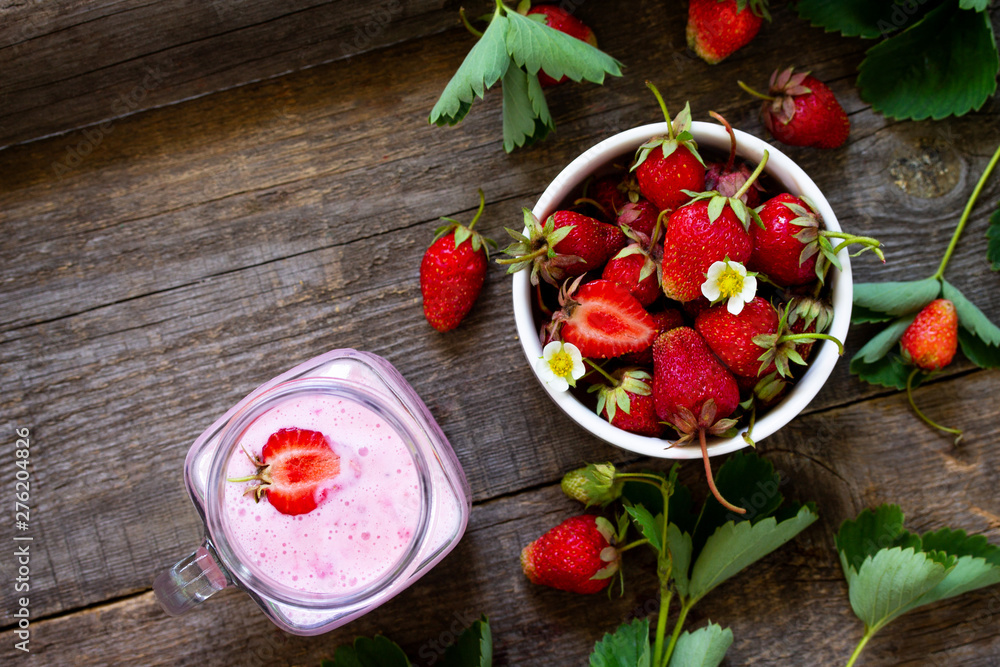 Dietary breakfast for summer time, vegan food concept. Fresh Strawberry milkshake on rustic wooden table. Free space for your text. Top view flat lay background.