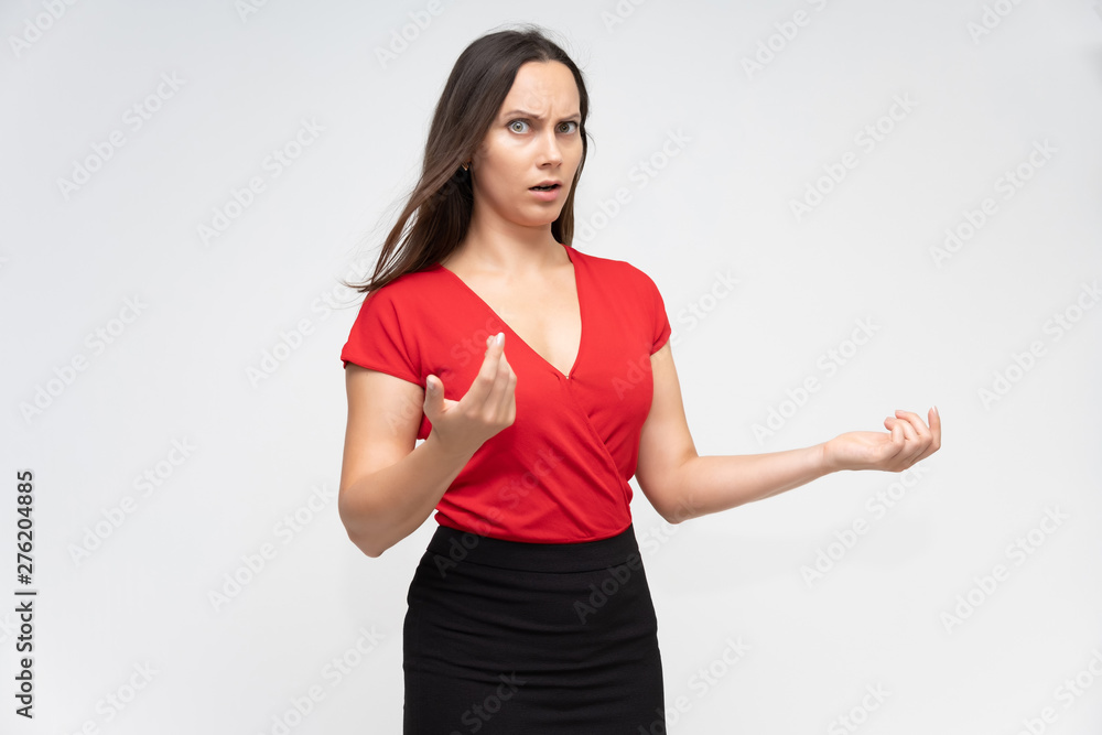 Portrait to the waist of a young pretty brunette woman of 30 years old in a bright red sweater with beautiful dark hair. Standing on a white background, talking, showing hands, with emotions Portrait to the waist of a young pretty brunette woman of 30 years old in a bright red sweater with beautiful dark hair. Standing on a white background, talking, showing hands, with emotions