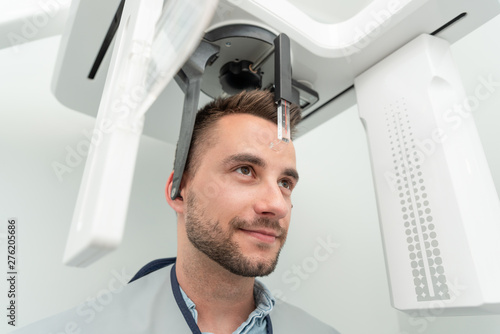 Patient standing in x-ray machine at dental clinic