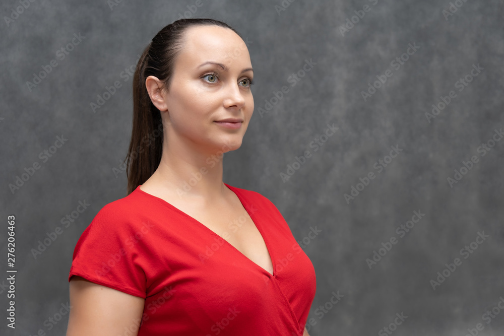 portrait of a young fashionable pretty brunette woman 30 years old with beautiful dark hair in a red sweater. On a gray background, smiling, showing emotions. portrait of a young fashionable pretty brunette woman 30 years old with beautiful dark hair in a red sweater. On a gray background, smiling, showing emotions.