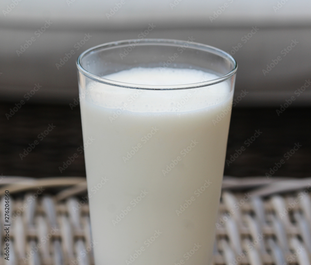 Self made vanilla milkshake in glass on reed background Self made vanilla milkshake in glass on reed background