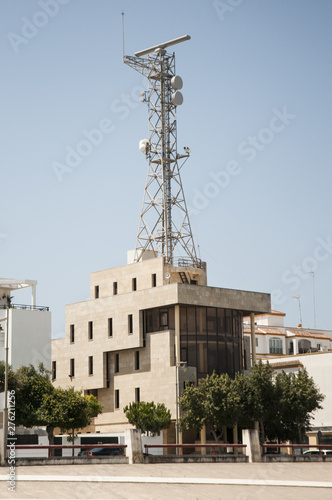 Traffic control tower of boats in the port of Chipiona over building and blue sky