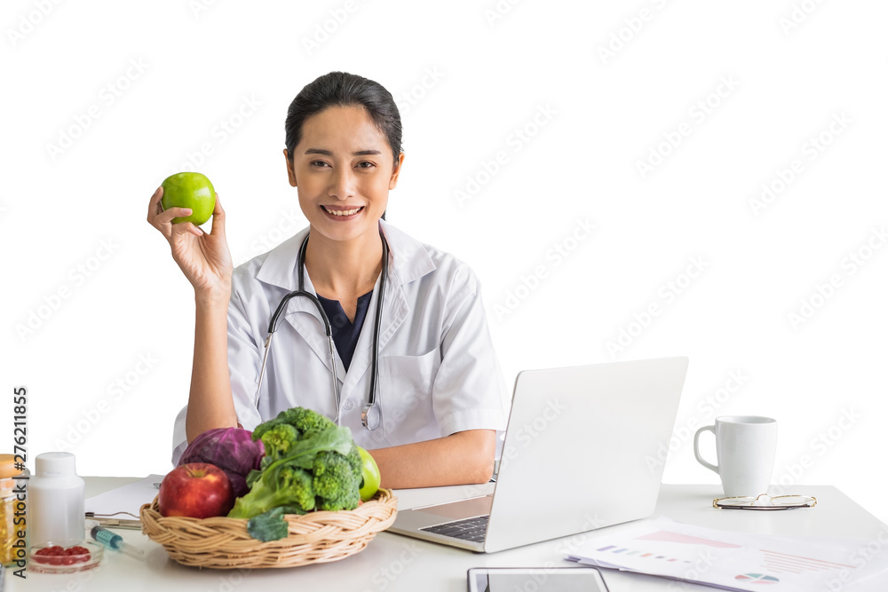 A young woman doctor nutritionist smiling siting working on her laptop in her office holding green apple in front of isolated white background. A young woman doctor nutritionist smiling siting working on her laptop in her office holding green apple in front of isolated white background.