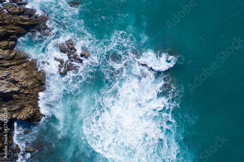 Aerial drone view of ocean's beautiful waves crashing on the rocky island coast © stryjek