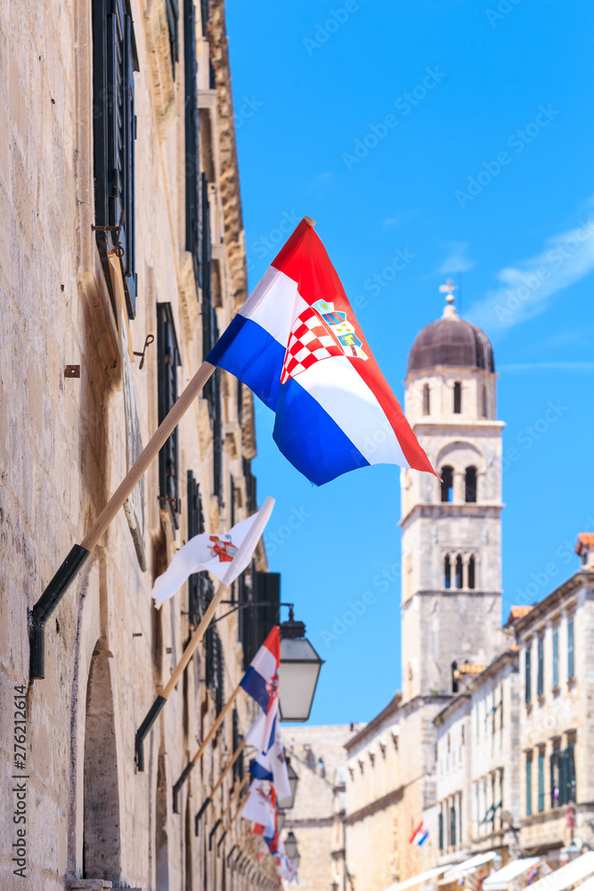 The Croatian flag on the main street (Stradun) in Dubrovnik with the tower of the Franciscan Church and Monastery in the background.