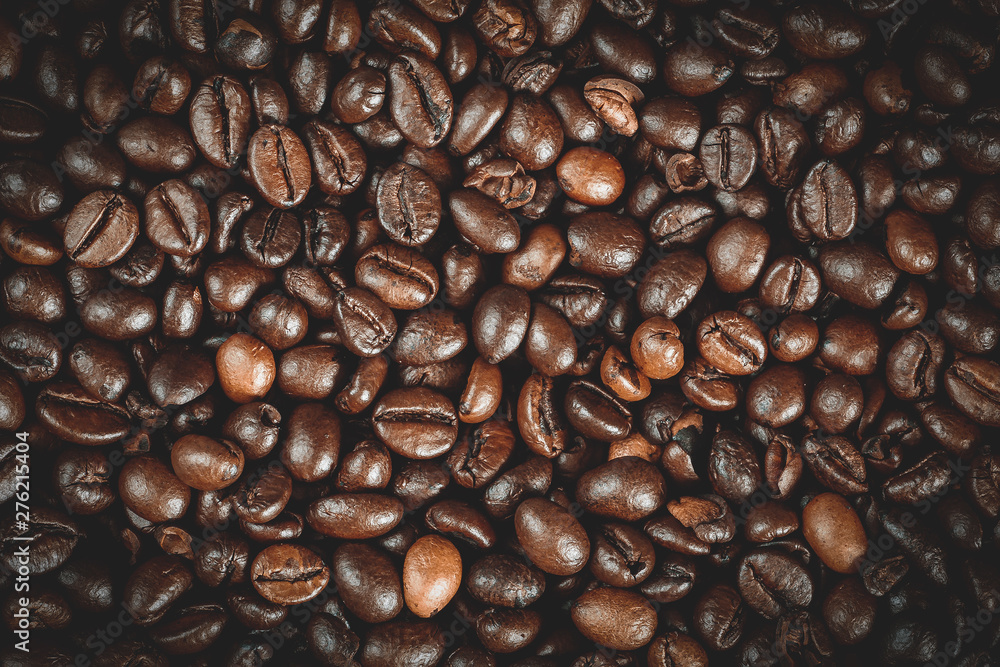 Naklejka premium Roasted coffee beans background, macro photo