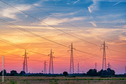 Power transmission lines in the green field in sunset 