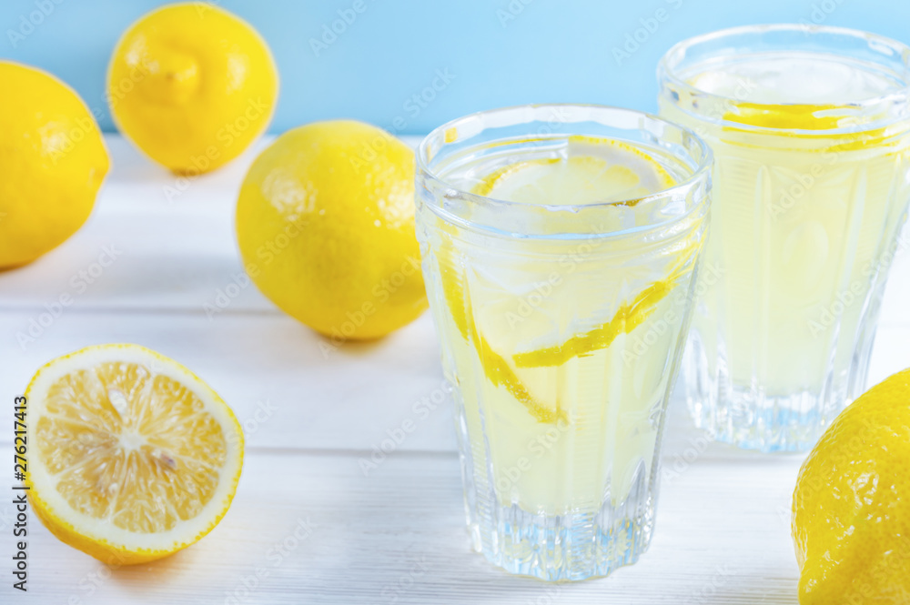 Glasses with summer drink lemonade and lemon fruit on white wooden table. Glasses with summer drink lemonade and lemon fruit on white wooden table.