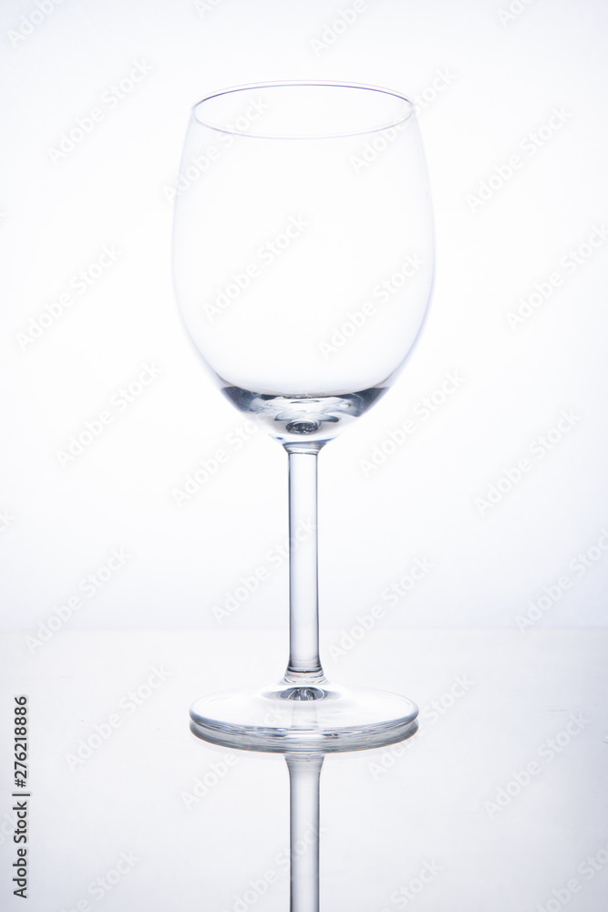 Empty glass wine goblet on white background with reflection