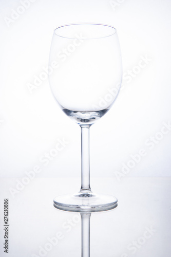 Empty glass wine goblet on white background with reflection