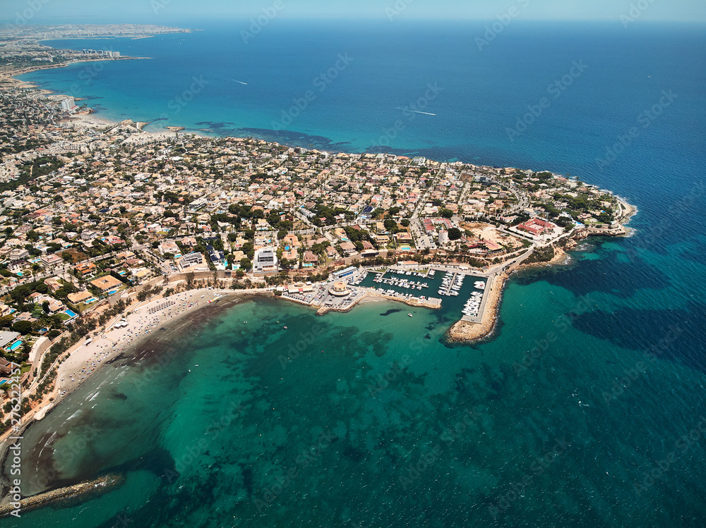 Aerial image drone point of view turquoise bay of Mediterranean Sea waters and coastline Cabo Roig Torrevieja from above at summer, Province of Alicante, Costa Blanca, Spain