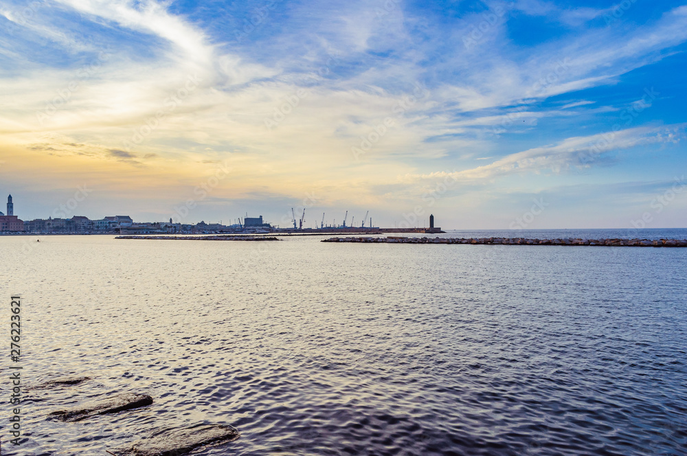 Spectacular sunset on the sea coast in Italy with blue sky and sea harbor on the background