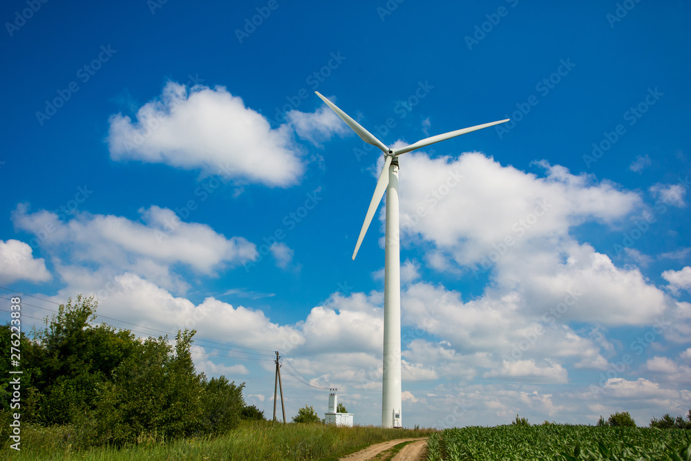Energy concept. Single wind turbine set up in farmland in summer. Alternative electricity source