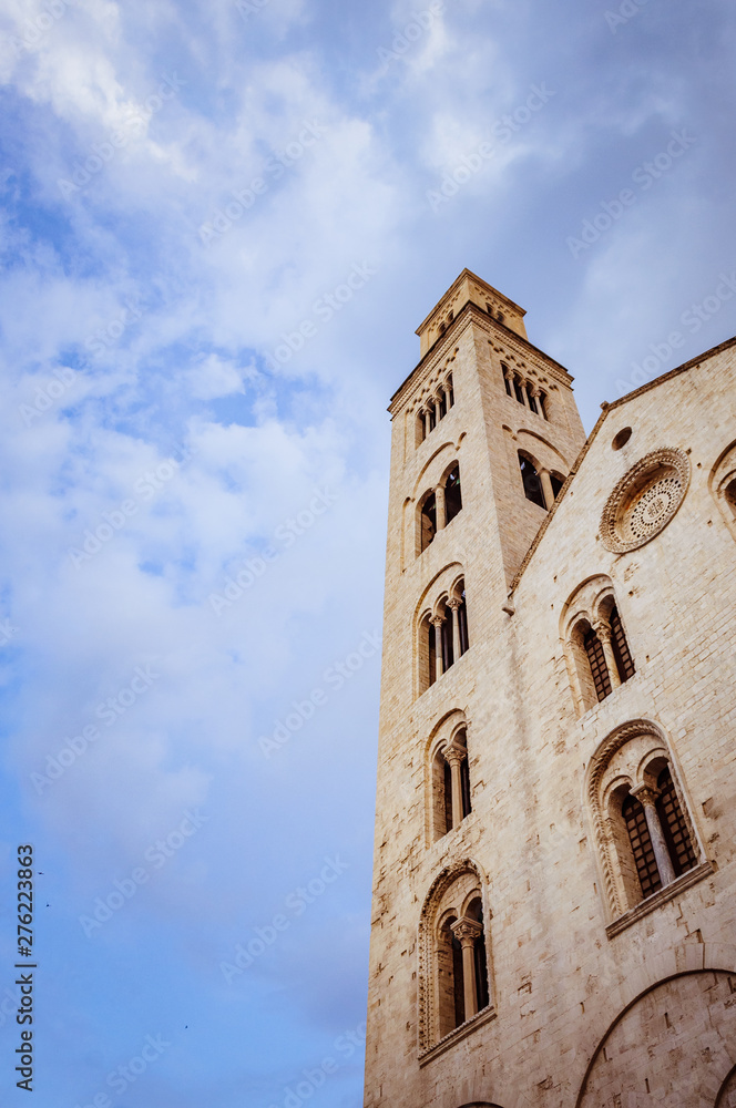 HIgh tower of catholic cathedral with blue cloudy sky on the background