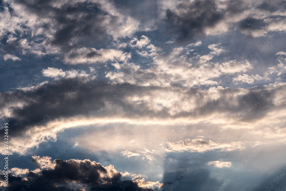 Fototapeta premium in the sky, the sun's rays pass through the clouds