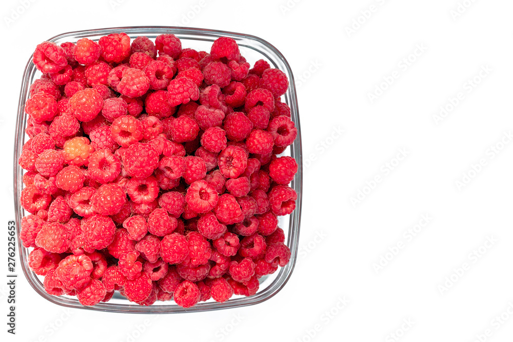 Fresh organic raspberries in a glass plate. isolated on white background. copy space