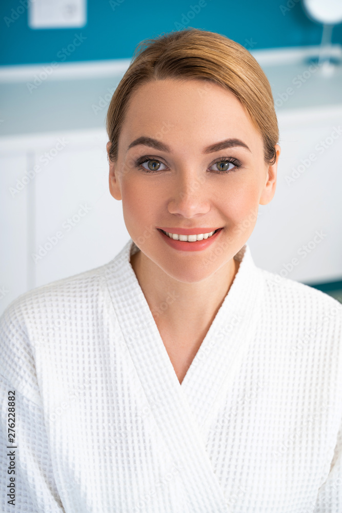 Woman in white posing indoors and smiling Woman in white posing indoors and smiling