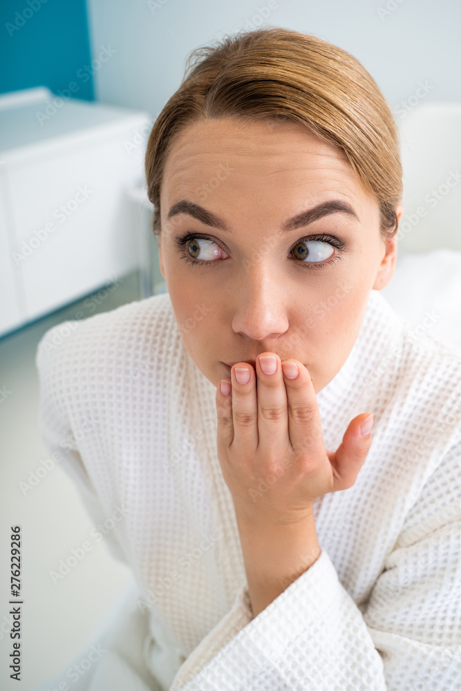 Emotional woman expressing suspicion and closing her mouth Emotional woman expressing suspicion and closing her mouth