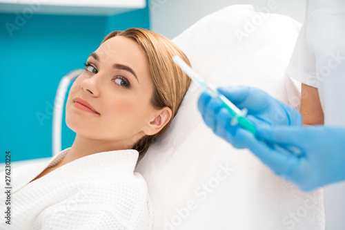 Calm lady smiling and waiting for injection to start